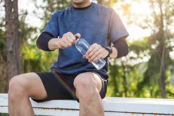 Caucasian man short beard drinking refreshing water while sitting and resting after workout exercises, health care concept