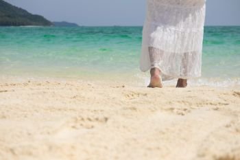 a beautiful carefree Woman relaxing at the beach enjoying her sun dress freedom wear
