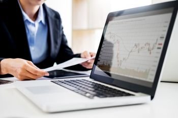 Investor analyzing financial reports of stock trading Market Graph investment charts on computer monitor screen in the office