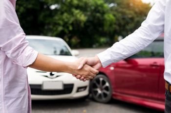 Customer shake hand with auto insurance agents examining car crash owner after agreeing find a friendly agreement after a car accident to terms of insurance On the road.