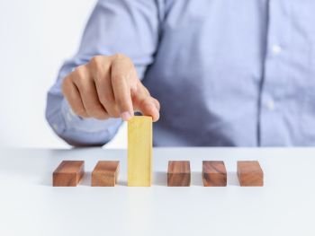 businessman and outstanding wooden toy block, different concept