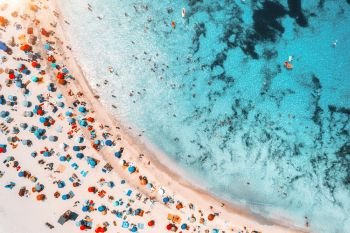 Aerial view of sandy beach with colorful umbrellas, swimming people in sea bay with transparent blue water at sunset in summer. Travel in Mallorca, Balearic islands, Spain. Top view. Landscape