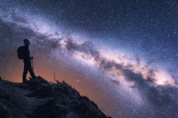 Space with Milky Way and silhouette of a woman with backpack at night in Nepal. Young girl on the mountain peak and starry sky. Sky with stars. Trekking. Landscape with bright milky way and traveler