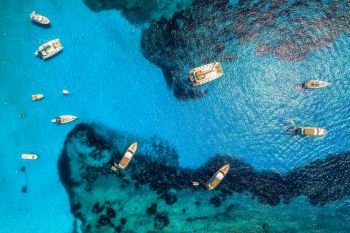 Aerial view of boats and luxury yachts in transparent blue sea at sunny day in Spain. Colorful landscape with marina bay, azure water. Balearic islands. Top view. Travel in Europe. Summer vacation