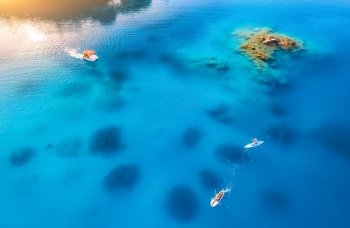 Aerial view of people on floating sup boards on blue sea, boat, rock, stones at sunset in summer in Oludeniz, Turkey. Tropical landscape. Kayaks on clear water. Active travel. Top view of canoe. Sport