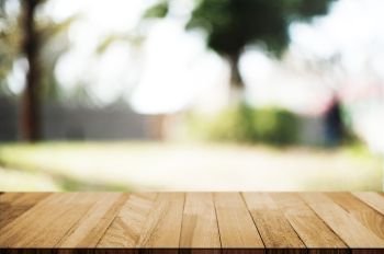 empty wood table top over blur outdoor green nature background.