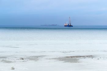winter beach, ship on the horizon of the frozen sea. ship on the horizon of the frozen sea