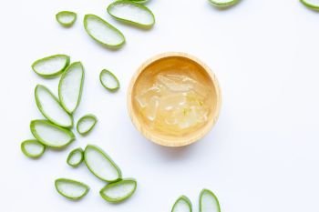 Aloe vera slices with aloe vera gel in wooden bowl on white background. Copy space