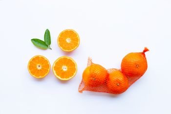 High vitamin C. Orange in net bag with ripe half of orange on white background. 