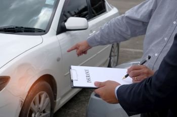 Loss Adjuster Insurance Agent Inspecting Damaged Car