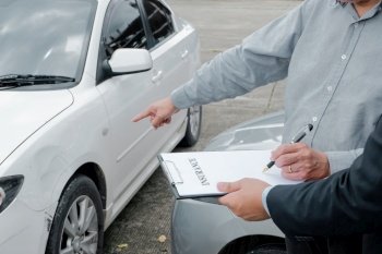 Loss Adjuster Insurance Agent Inspecting Damaged Car. 
Sales manager giving advice application document considering mortgage loan offer for car  insurance 