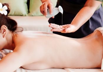 Young asian woman enjoying natural oil treatment massage on spa table
