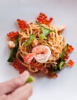 Fusion Italian - Thai food. Spicy spaghetti Tom Yum Kung with shrimp and salmon roe.
