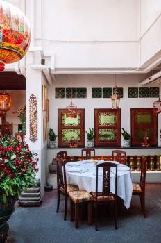 DEC 18, 2013 Singapore - Traditional Peranakan restarant in old Baba Nyonya style house, with open space for light at center. Fully furnished with Chinese style furniture