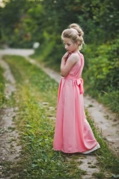 Girl in long pink dress posing on nature background.. A beautiful portrait of a girl in evening dress among the garden 6651.