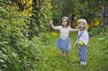 The children walk along the summer garden.. A boy and a girl walking in the green garden 4760.