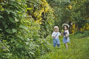 The children walk along the summer garden.. A boy and a girl walking in the green garden 4762.