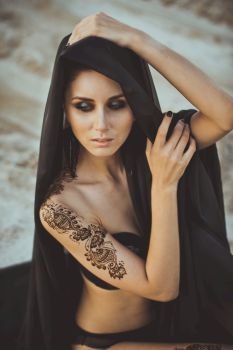 The girl in underwear lies among sand.. List on a female body mehndi by means of henna 3444.