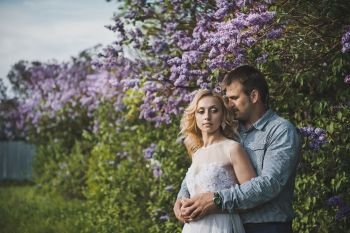 Portraits of a young pair in lilac bushes.. Newly-married couple among lilac bushes 3152.