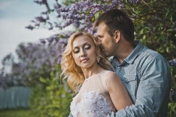 Portraits of a young pair in lilac bushes.. Newly-married couple among lilac bushes 3154.