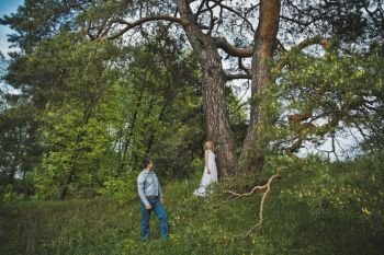 Newly-married couple in the wood about a tree.. Young pair against a huge pine 3175.