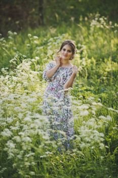 Portrait of a happy pregnant woman in a clearing of white flowers kupyr forest.. Simple female beauty in the meadow of flowers cupira forest 1712.