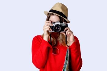 Portrait of young woman in summer hat standing with vintage camera. Travel concept. 
