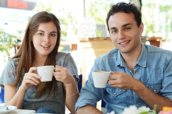 Young attractive couple enjoying a coffee at the coffee shop. Outdoors.