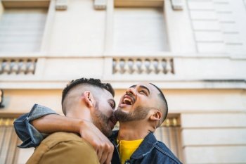 Portrait of happy gay couple spending time together and hugging in the street. Lgbt and love concept.. Gay couple spending time together.