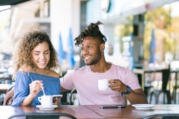 Young couple enjoying together while drinking a cup of coffee at a coffee shop.