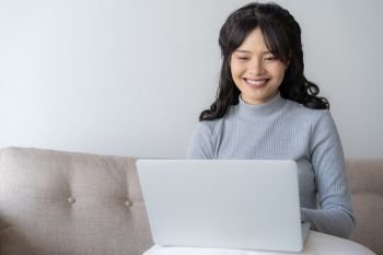 Asian women using laptop at home,Asian girl sitting and smiling working at home