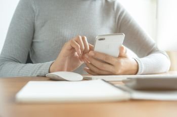 The hand of Asian women are using smartphone and computer in the office. Young women are using phones in social networks.