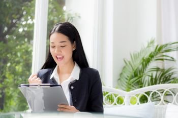 Asian business woman holding clipboard folder and gesture glad in the office.