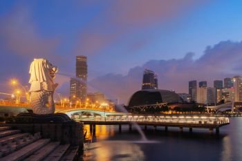 Singapore City - July 29, 2018 : Merlion and skyscrapers buildings at sunrise and twilight sky.