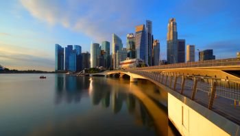 Panorama of Downtown Singapore city in Marina Bay area and reflection. Financial district and skyscraper buildings at sunset