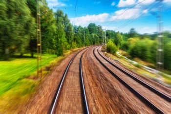 Train driver cabin view of the railroad tracks in summer with motion blur effect