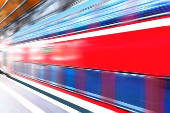 Creative abstract railroad travel and railway transportation industrial concept: modern red high speed electric passenger commuter double deck train at station platform with motion blur effect