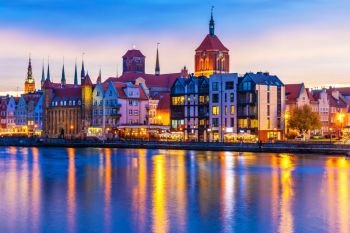 Scenic view of the Old Town pier architecture of Gdansk, Poland in sunset at the Motlawa River harbor embankment with medieval port and historical ships