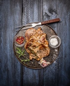 roast pork with garlic, salt and red sauce on iron baking tray rusticwith fork on wooden rustic background, top view