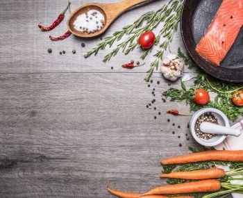 salmon fillet in a pan with herbs, vegetables and spices place for text,frame on wooden rustic background top view