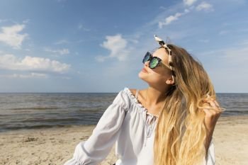 Young sexy blonde woman with long hairs in sunglasses.Beach and sea background.Summer lifestyle
