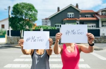 Two unrecognizable young women showing poster with metoo hashtag. Women showing poster with metoo hashtag