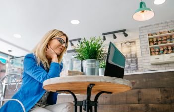 Woman working with the laptop in a coffee shop. Woman working with the laptop