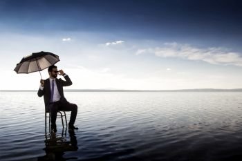 A business man in a suit with an umbrella on top of a lake. amazing surreal business world