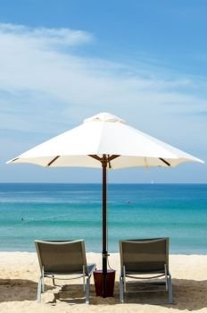 White umbrella and deckchair on the beach. Studio Photo. White umbrella and deckchair on the beach