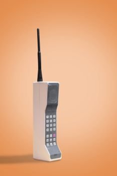 Retro cellular mobile phone on a vintage orange background with copy space and room for text