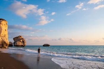 A barefooted boy plays at the beach againt the Petra tou Romiou rocks bathed in afternoon light, in Paphos, Cyprus. The beach is considered to be Aphrodite’s birthplace in Greek mythology.