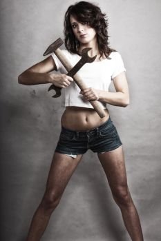 Sex equality and feminism. Sexy girl holding hammer and wrench spanner tools. Attractive woman working as repairman.