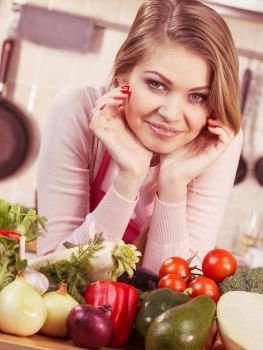 Funny joyful young woman, cooking chef having many healthy vegetables on table. Tomatoes, onion, lettuce, pepper. Vegetarian lifestyle concept.. Woman having vegetables on table