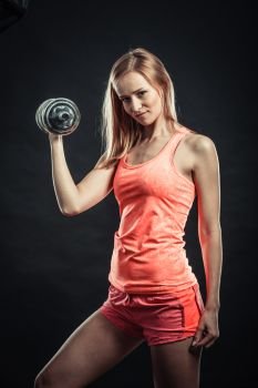 Bodybuilding. Strong fit woman exercising with dumbbells. Muscular blonde girl lifting weights studio shot on black background